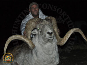 A hunter poses with his sheep at the conclusion of Marco Polo Argali Hunting